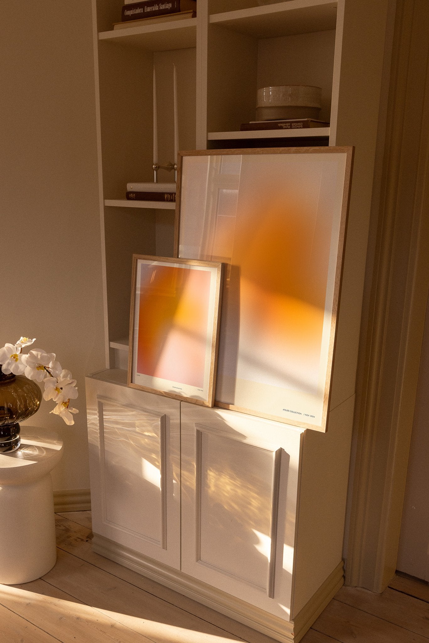 Colorful orange art prints on shelf