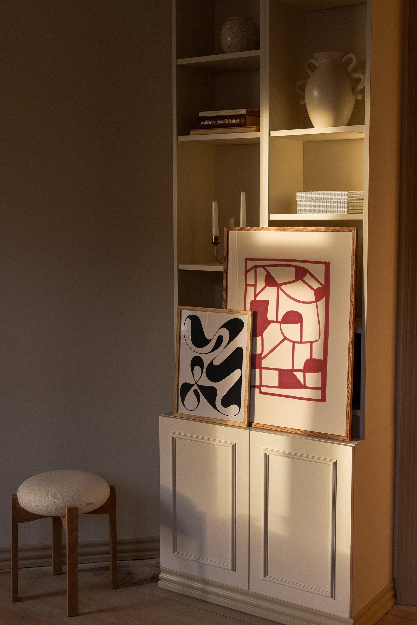 Abstrakte kunstplakater på reol